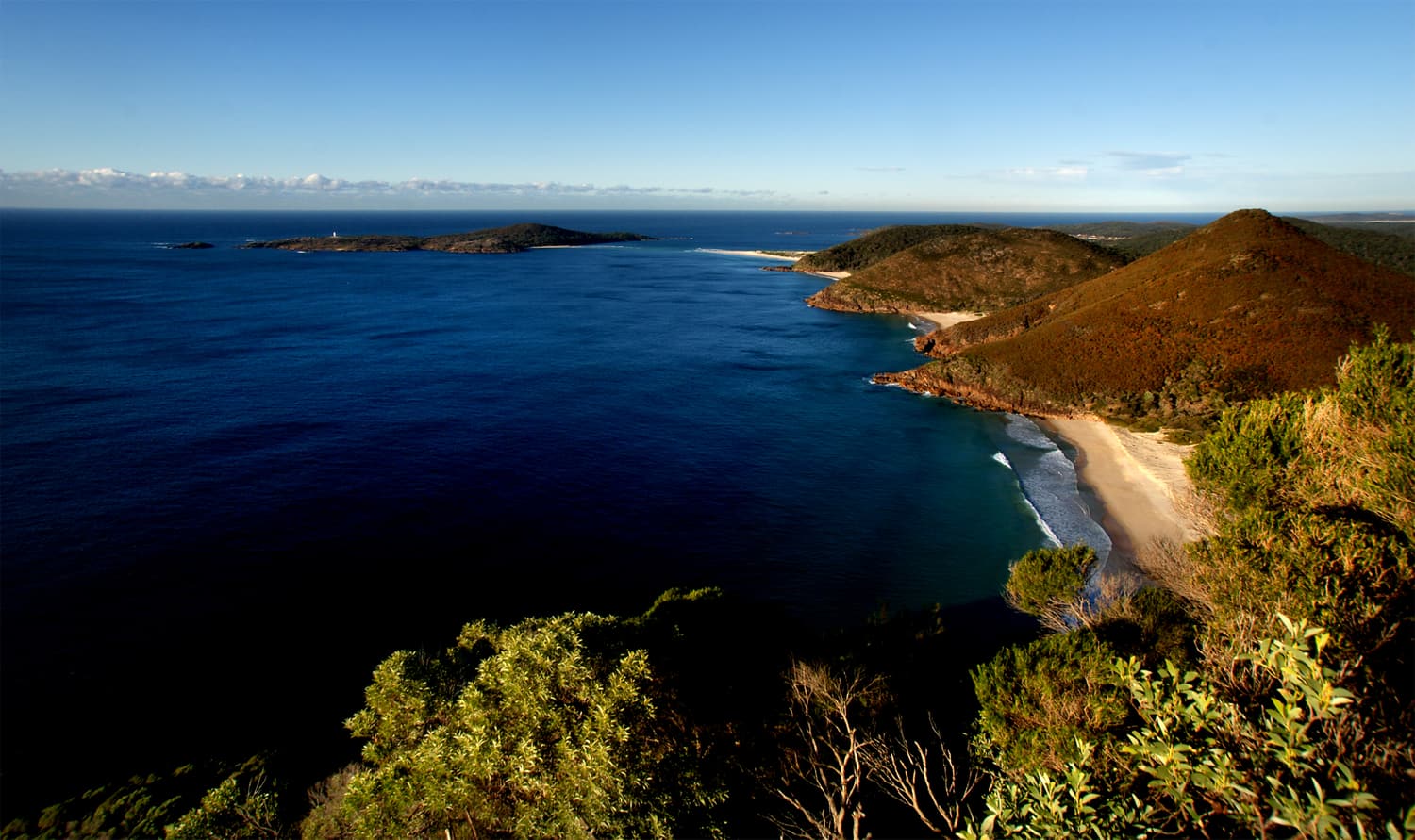 Bewaldete Landzungen, eine Sandbucht und vorgelagerte Inseln, vom Tomaree Head in Port Stephens gesehen