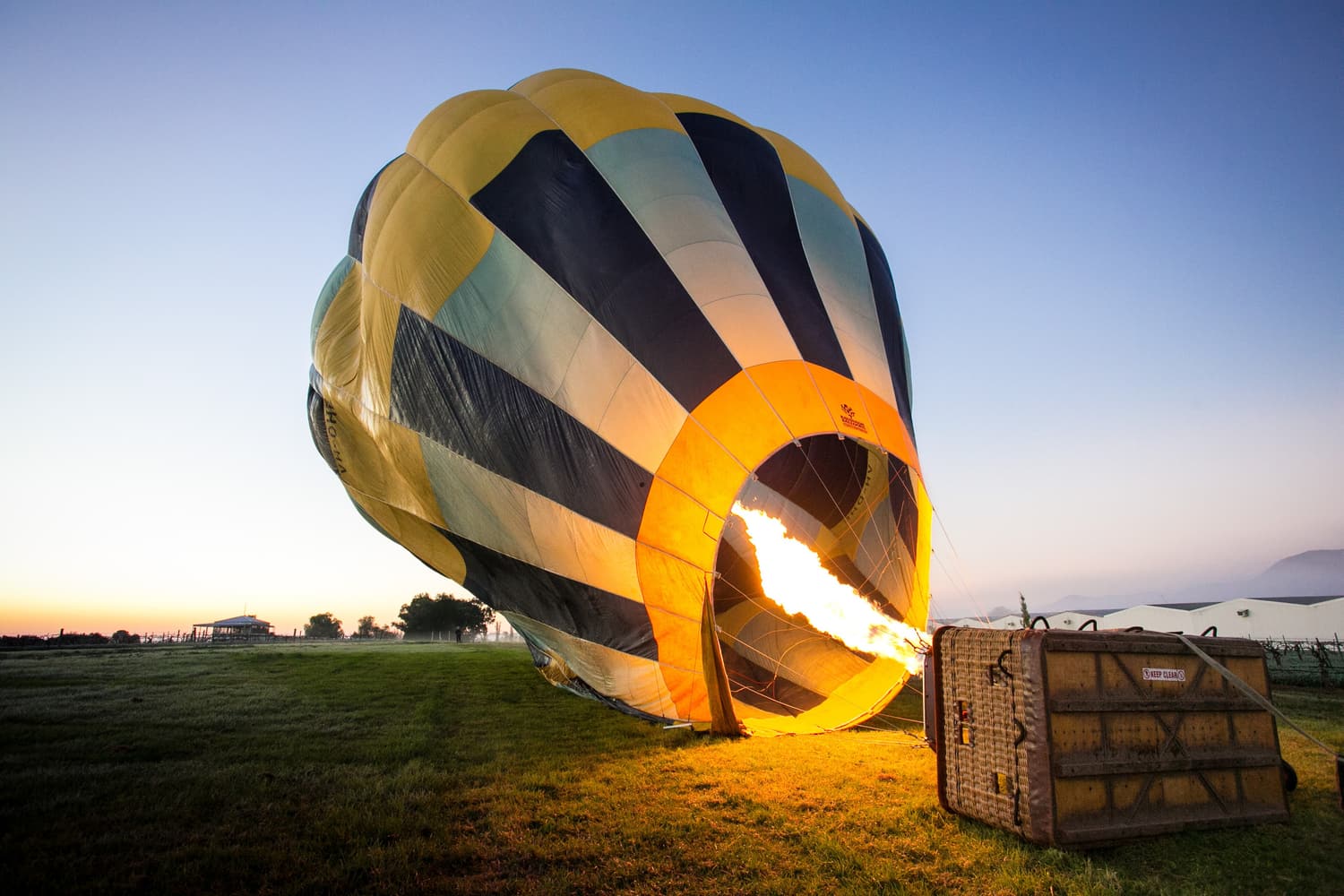Ein Heißluftballon wird vor der Morgendämmerung in Pokolbin mit der Brennerflamme aufgerichtet